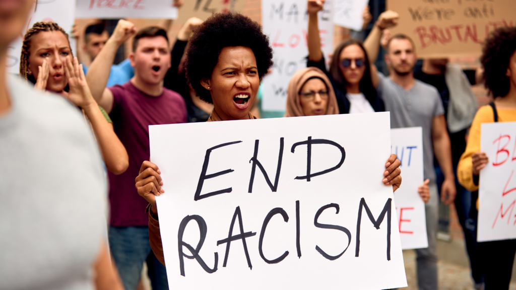 Woman holding sign that says end racism - Avoshea Therapy